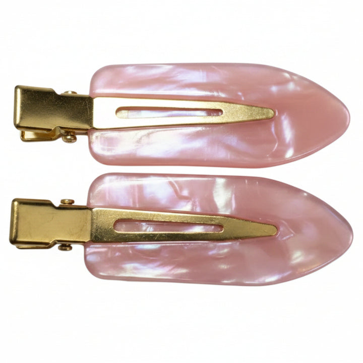 Two light pink mother-of-pearl hair clips with gold-tone metal clasps, displayed on a clean white background.