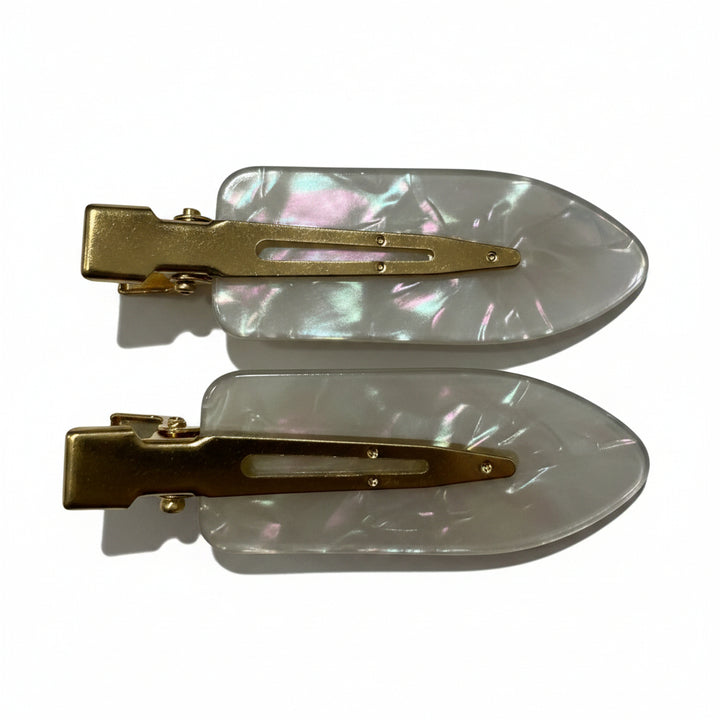 Two hair claw clips with iridescent white mother-of-pearl resin bodies and gold-tone metal clasps, shown on a plain white background.