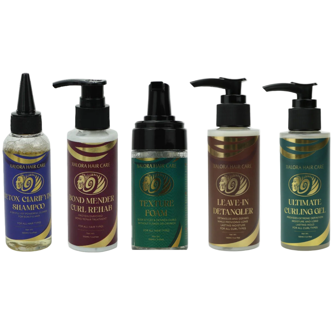 Set of five hair care products with black pump dispensers on a white background