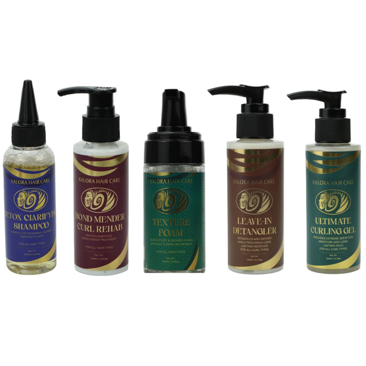 Set of five hair care products with black pump dispensers on a white background