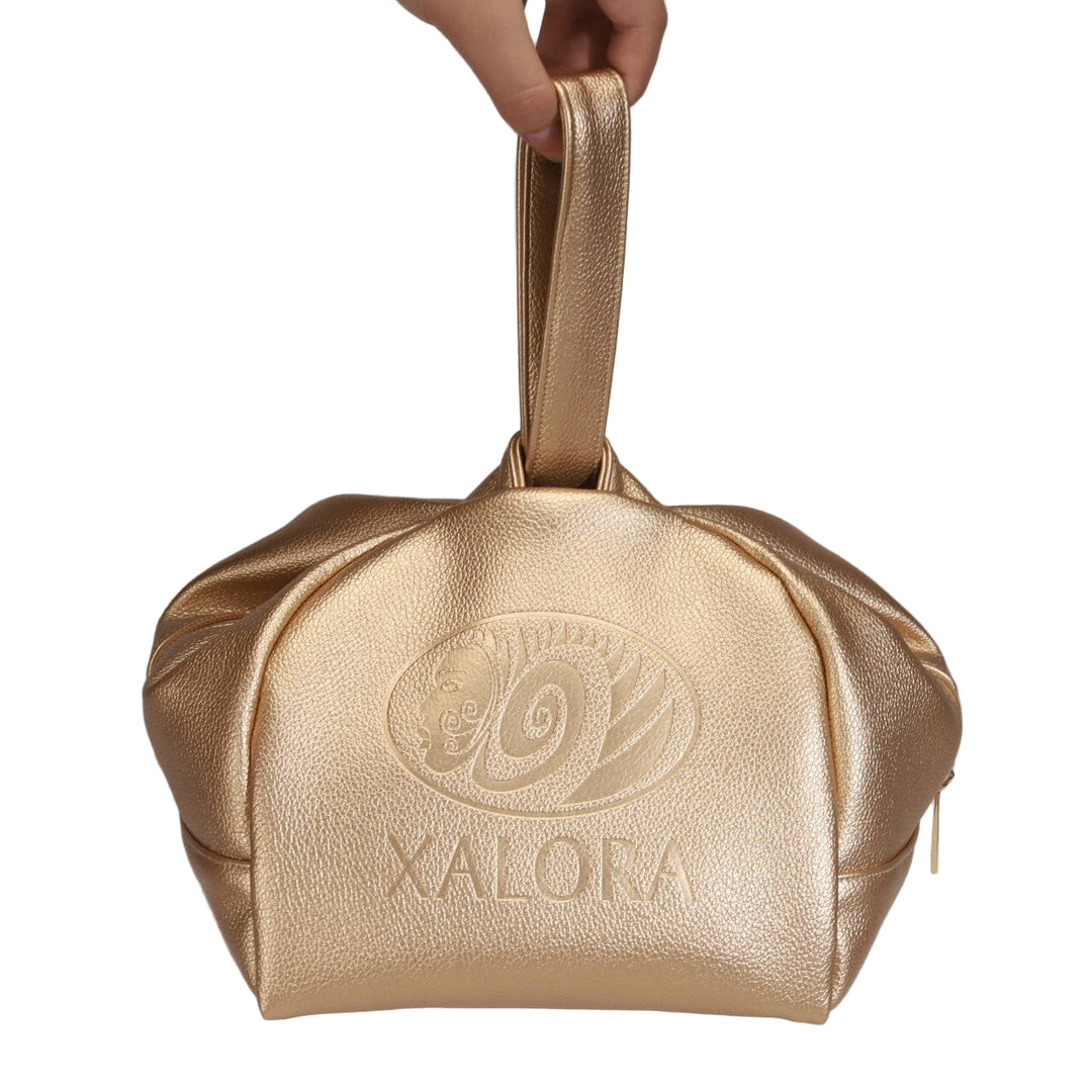 Gold handbag with 'Xalora' branding held by a hand on a light background