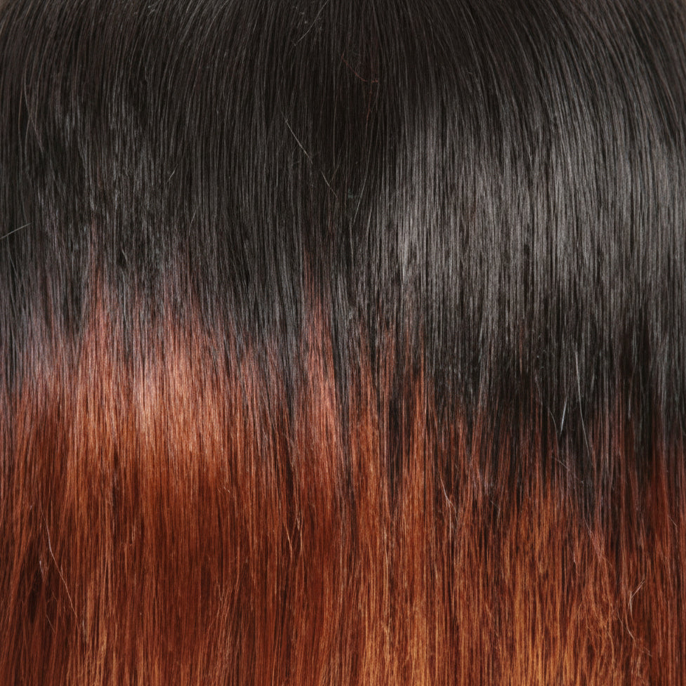 A close-up of straight hair with a dark black-to-medium brown ombré color gradient.