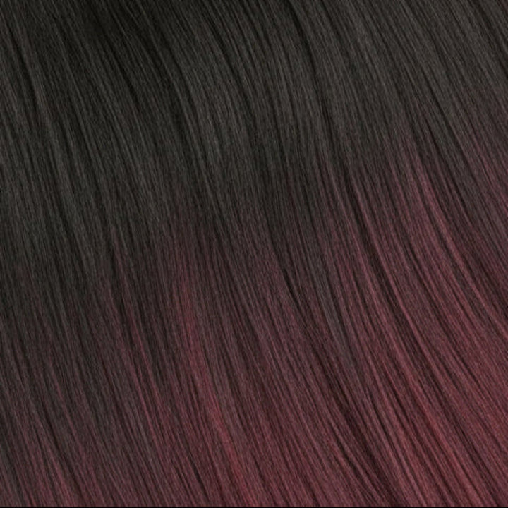 A close-up texture shot of dark, wavy hair with a deep burgundy or plum undertone.