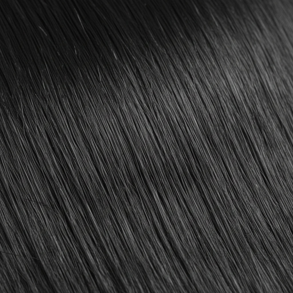 A close-up texture shot of straight, glossy black hair with soft waves, filling the entire frame.
