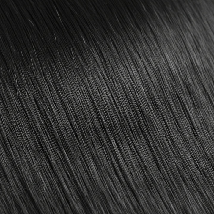 A close-up texture shot of straight, glossy black hair with soft waves, filling the entire frame.
